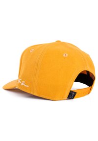 Sárga kordbársony baseball sapka lapos viszorral, állítható snapback zárással, kör alakú szellőzőnyílásokkal és hímzett díszítéssel az elülső részen.
