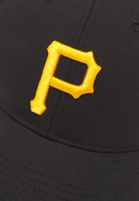 Juodas baseball kepurė, pagaminta iš audinio, su ryškiai geltona siuvinėta raide "P", turinčia smailius akcentus ant išorinių kraštų.