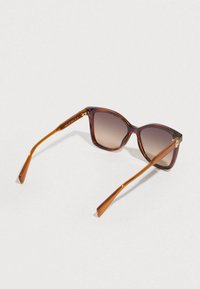 Teknősbéka mintás napszemüveg barna átmenetes lencsékkel, szögletes keret kialakítással és elegáns, kúpos szárakkal. Arany díszítés a szárnál.