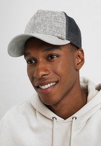 Gray and black cap with a textured fabric front, curved visor, and mesh back; features a wooden logo accent on the side.