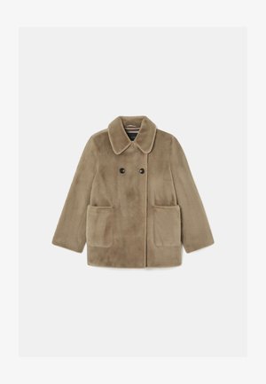 Ruskea tekoturkisviitta, jossa on kaulus, kaksoispainikkeet, kaksi etutaskua ja pehmeä rakenne. Laatikkomainen muotoilu suorin hihoin.