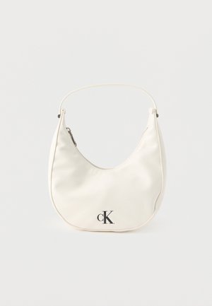 Kleine weiße halbmondenförmige Handtasche mit kurzem Trageriemen, Reißverschluss und schwarzem "cK"-Logo auf der Vorderseite.