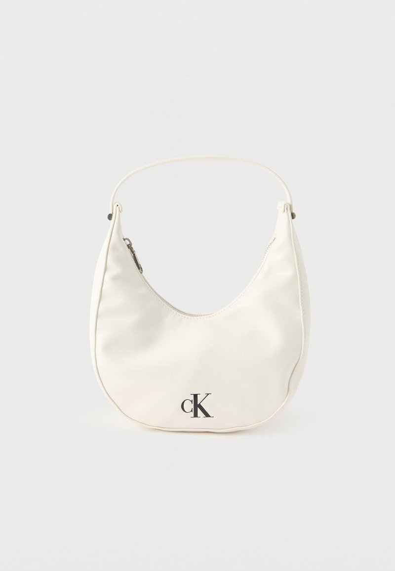 Μικρή λευκή τσάντα σε σχήμα ημισελήνου με κοντό λουράκι, κλείσιμο με φερμουάρ και μαύρο λογότυπο "cK" μπροστά.