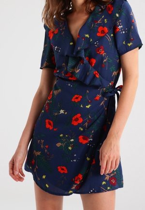 Robe portefeuille florale bleu marine avec manches courtes, encolure à volants et motifs de coquelicots rouges. Ceinture à la taille, tissu léger et coupe décontractée.