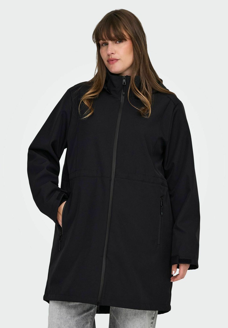 Chaqueta impermeable negra con un collar alto, cremallera completa, mangas largas y bolsillos laterales. Textura suave y un diseño de corte recto.
