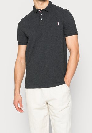 Dunkelgraues Poloshirt mit Kragen, drei Knöpfen und einer Brusttasche. Verfügt über eine kleine rot-weiß-blaue Akzentuierung auf der Tasche.