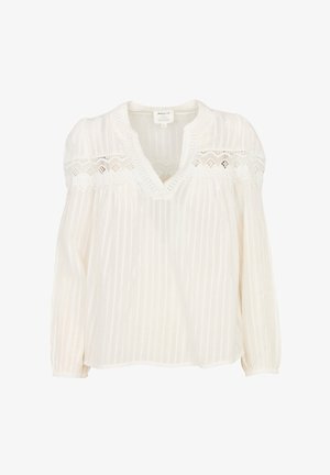 Camicia bianca ampia con scollo a V, con dettagli in pizzo trasparente sulle spalle, texture a righe e maniche lunghe a sbuffo.