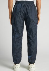 Marina cargo byxor i lätt, texturerat material har en elastisk midja och sidofickor, och smalnar av vid anklarna.