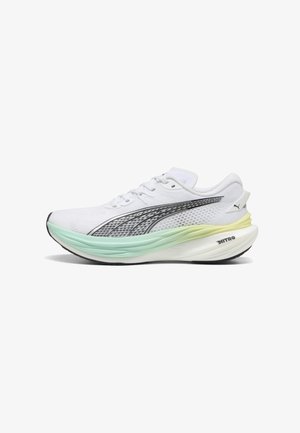Chaussure de sport blanche avec une tige texturée, des accents noirs et une semelle dégradée allant du vert menthe au jaune. Elle présente des lacets traditionnels et un logo.