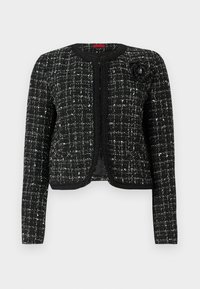Schwarze und weiße Tweedjacke mit strukturierter Optik, tailliertem Schnitt, rundem Ausschnitt und floralem Akzent an der linken Schulter.