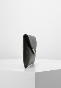 Černé kožené psaníčko s texturovaným povrchem a elegantním stříbrným akcentem. Skládaný design nabízí minimalistický tvar.