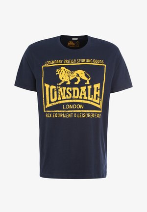 Navy krāsas kokvilnas t-krekls ar apaļu kakla izgriezumu. Izceļas ar dzeltenu novecojušu grafiku ar lauvu un tekstu: "Lonsdale London Box Equipment & Leisurewear."