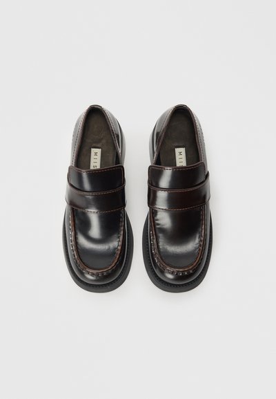 Black leather loafers with a glossy finish, featuring a wide strap across the instep, contrast stitching, and a rounded toe shape.