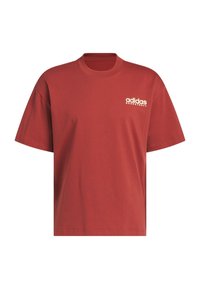 Volnější tričko s krátkým rukávem z červeného bavlněného materiálu. Má kulatý výstřih a bílé logo "adidas BASKETBALL" na levé části hrudi.