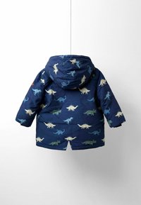 Námořnická modrá prošívaná bunda s dinosaurími vzory v zelené a béžové. Obsahuje kapuci a dlouhé rukávy, navržena pro teplo a pohodlí.