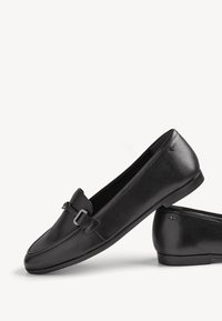 Mocassins pour femmes en cuir noir avec petit détail de boucle, bout arrondi uni et semelles plates, présentés sur fond blanc.