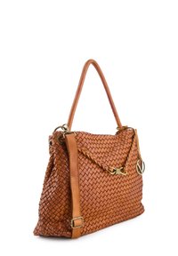 Brown leather handbag with woven texture, braided detail, single top handle, adjustable strap, and gold circular charm on white background.
