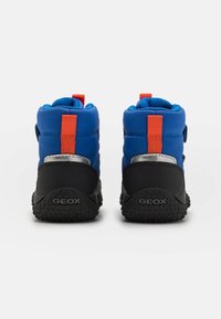 Bottes imperméables bleues avec semelles en caoutchouc noires, ornées d'accents orange et de bandes Velcro. Arrière texturé avec le logo Geox.