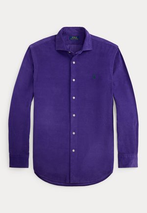 Chemise en coton violette à manches longues avec un col boutonné, comportant un logo vert sur la poitrine gauche et des boutons blancs sur le devant.