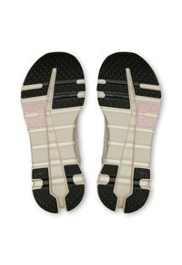 Fekete, bézs és rózsaszín szakaszokkal rendelkező cipőtalpak, amelyek texturált mintázatú és hornyolt felületekkel rendelkeznek a tapadás és a rugalmasság érdekében.