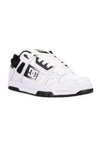 White and black athletic sneaker with a rubber sole, textured leather upper, round toe, and DC logo on the side. Laced closure and padded collar.