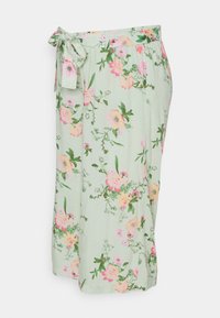 Saia de estampado floral em tecido verde claro, com flores em rosa e amarelo. Inclui uma faixa de tecido na cintura e um silhueta fluida.