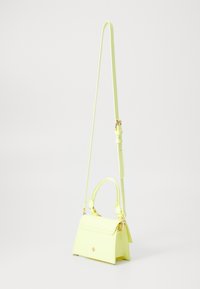 Sac à main en cuir synthétique jaune avec un design structuré, une poignée courte, une bandoulière réglable et des accents métalliques dorés.