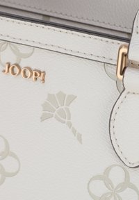 Borsa a mano in pelle bianca con un delicato motivo floreale in rilievo e un logo dorato. Include accessori coordinati e cuciture dettagliate.