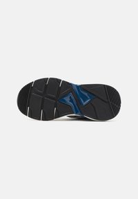 Schwarze Sportschuh-Sohle mit strukturiertem Gummi, einem geometrischen blauen Akzent und flexiblen Rillen für verbesserten Grip und Beweglichkeit.