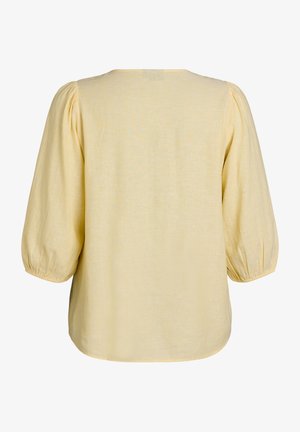 Blouse jaune clair avec manches trois-quarts bouffantes et poignets élastiques, vue de dos sur fond blanc.