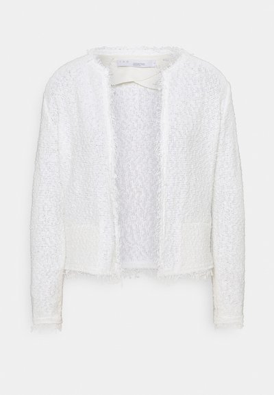 Valge tekstuuriga jakk fraktsed ääridega ja avatud esiosa. Omab kerget läiget ja kahte esist taskut. Ilma nuppude või sulgemisteta.