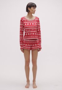 Rdeč komplet pižame z dolgimi rokavi z belimi vzorci cvetlic in pentelj, z okroglim izrezom in kratkimi hlačami. Iz mehkega, raztegljivega materiala.