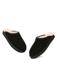Black suede slippers with plush cream lining, slip-on design, rounded toe, and textured black rubber sole for grip.