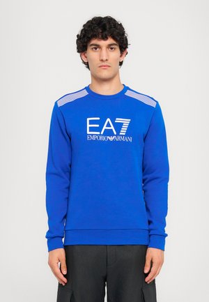 Sudadera azul de manga larga con cuello redondo. Presenta el logotipo blanco de EA7 y Emporio Armani en el frente. Rayas horizontales en los hombros.