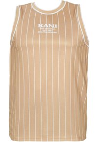 Beżowy top bez rękawów z wąskimi białymi paskami, okrągłym dekoltem oraz białym logo "KANI" na klatce piersiowej. Gładka struktura materiału.