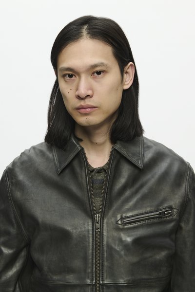 Black leather jacket with a zip front, point collar, and chest pocket. The material appears smooth with a slightly worn texture.