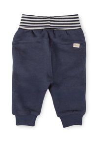 Navyblaue Sweatpants aus weichem Stoff, mit einem gestreiften elastischen Bund und schmal zulaufenden Bündchen. Enthält ein kleines Markenlabel.