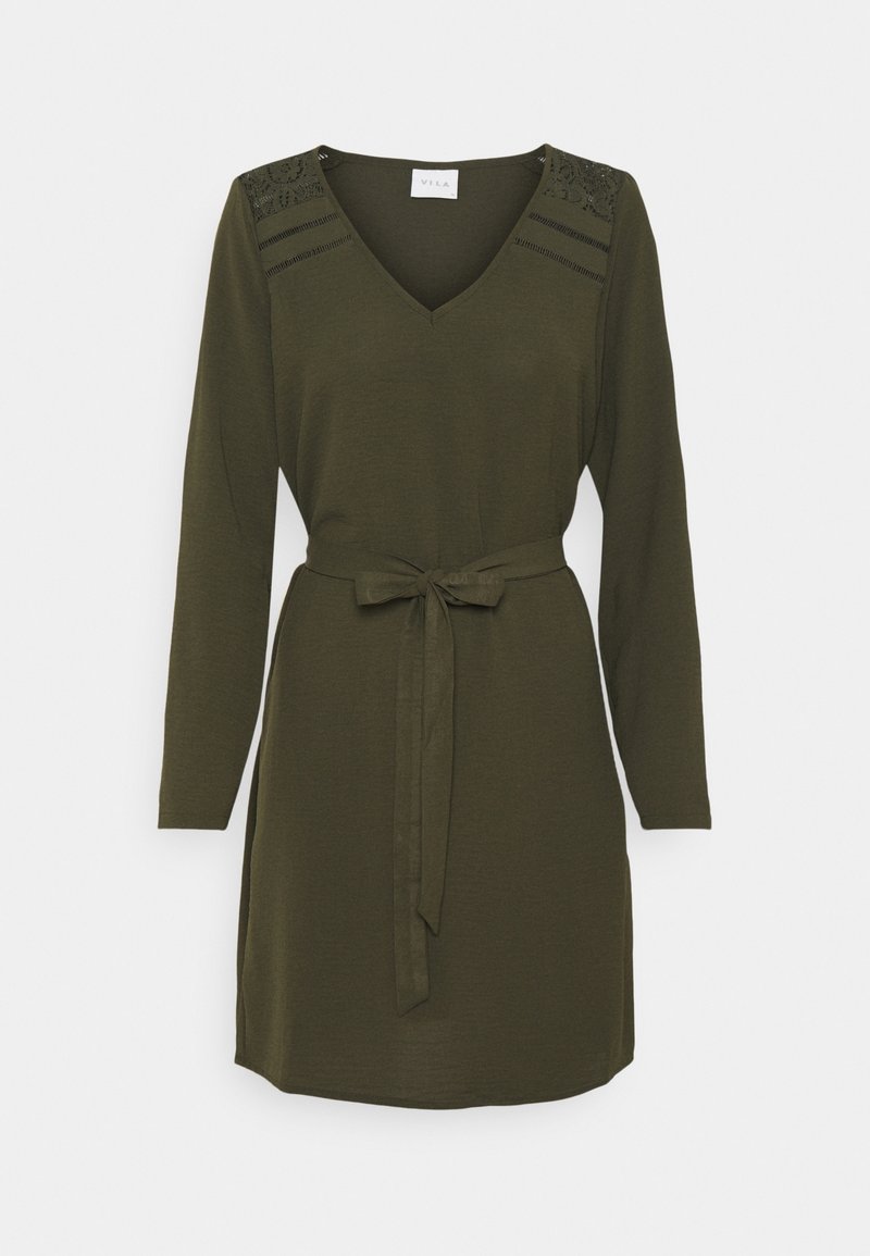 Olivgrön klänning med långa ärmar, V-ringning och ett matchande bälte i samma tyg i midjan. Har texturerade axelaccenter.