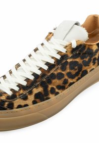 Leopard Muster Sneakers mit weißen Schnürsenkeln, weicher fellartiger Textur, tanfarbener Gummisohle und cremefarbenem Lederakzent im Bereich der Zunge.