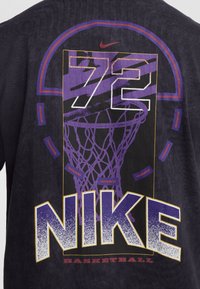 Black cotton t-shirt featuring a purple and yellow graphic of a basketball hoop, "72" and "NIKE BASKETBALL" text in bold styling.