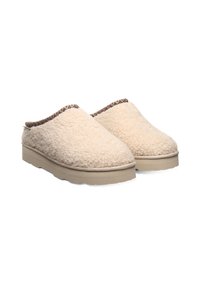Cream-colored slip-on slippers made of fluffy material with a textured upper, light beige sole, and a braided brown accent around the collar.