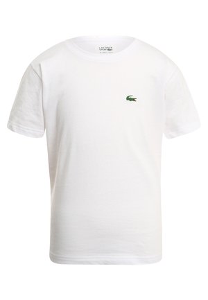 T-shirt en coton blanc avec un col rond et des manches courtes. Il arbore un petit logo de crocodile brodé vert sur la poitrine.