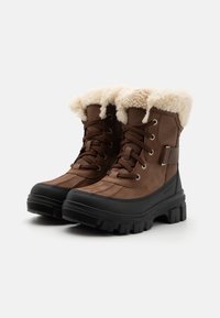 Brune vanntette støvler med en faux pelskant, snøresystem, svart gummisåle og teksturert såle for grep.