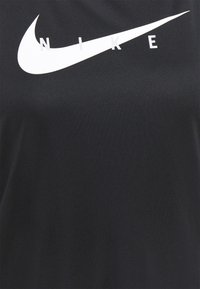 Svart tyg med en stor vit Nike swoosh-logotyp och bokstäverna N, I, K, E utspridda ovanför swooshen.