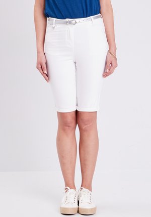 Shorts en denim blanc style bermuda avec ourlets roulés, présentant une coupe slim. Associés à un haut bleu et des baskets blanches à lacets. Ceinture en argent incluse.