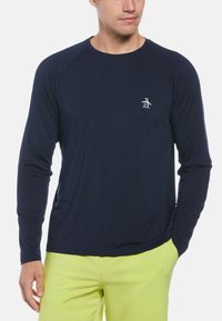 Langärmliges, marineblaues Hemd aus glattem Stoff, mit Raglanärmeln und einem kleinen weißen Pinguin-Logo auf der Brust.
