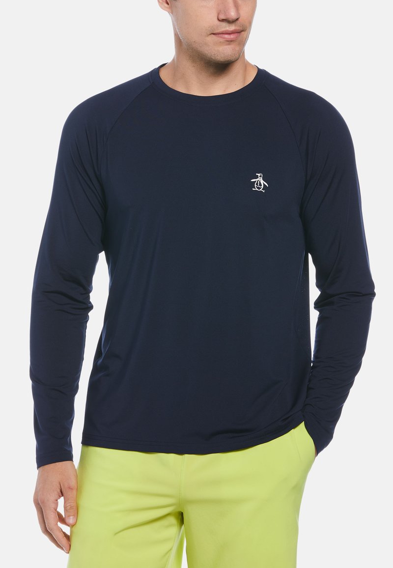 Langärmliges, marineblaues Hemd aus glattem Stoff, mit Raglanärmeln und einem kleinen weißen Pinguin-Logo auf der Brust.