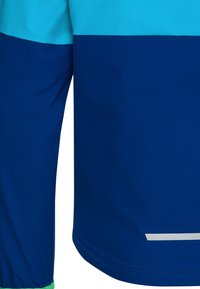 Μπλε και τυρκουάζ μανίκι μακριού μπουφάν και πλευρά, με μια μικρή οριζόντια αντανακλαστική λωρίδα κοντά στη βάση.