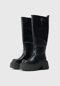 Crne čizmice do koljena od glatke kože s debelim platformskim potplatom, s detaljem kopče sa strane i zaobljenim prstom.