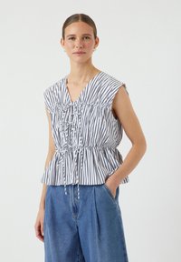 Haut peplum rayé en blanc et noir, avec un col en V, des détails froncés et une taille à cordon. Tissu léger avec une coupe décontractée.